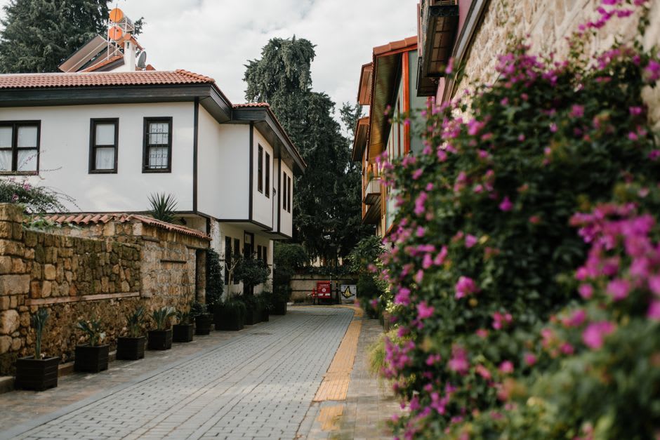 A narrow cobbled lane in Alaçatı lined with restored stone houses and bougainvillea