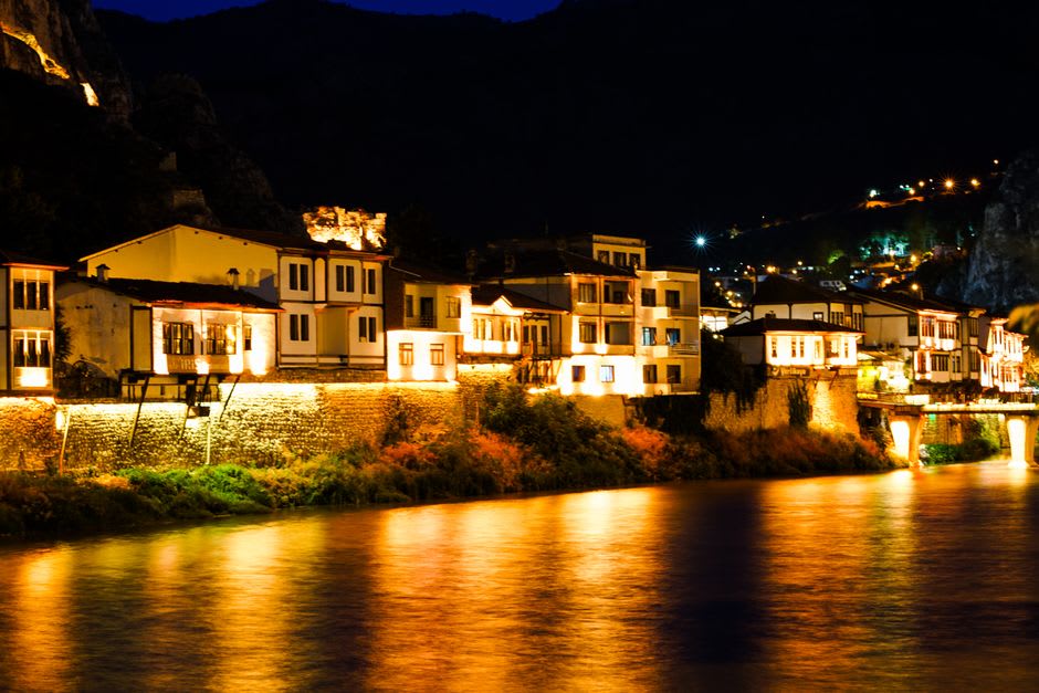 Timber Ottoman houses reflected in the Yesilirmak river at dusk in Amasya