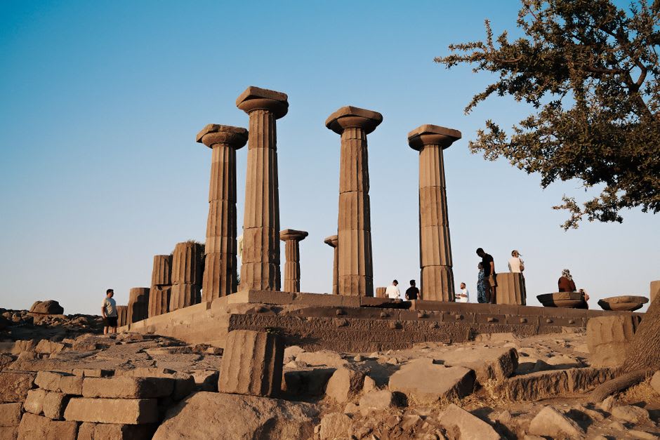 The Doric columns of the Temple of Athena at Assos silhouetted against the Aegean at sunset