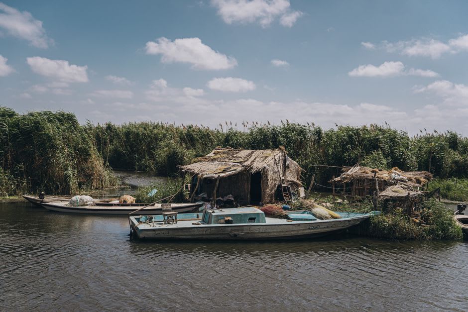 The wooden boats of Dalyan drifting past reed beds on the river delta