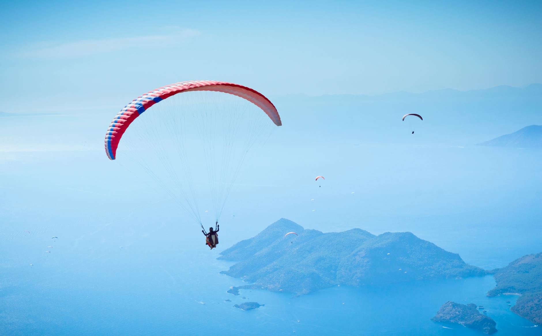 Paragliders soaring above the turquoise Fethiye coastline