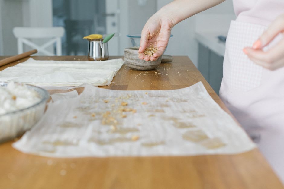 A craftsman hand-layering yufka dough for baklava in a traditional Gaziantep sweet shop