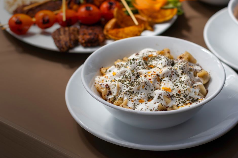 A plate of Kayseri-style mantı dumplings topped with yogurt and paprika butter