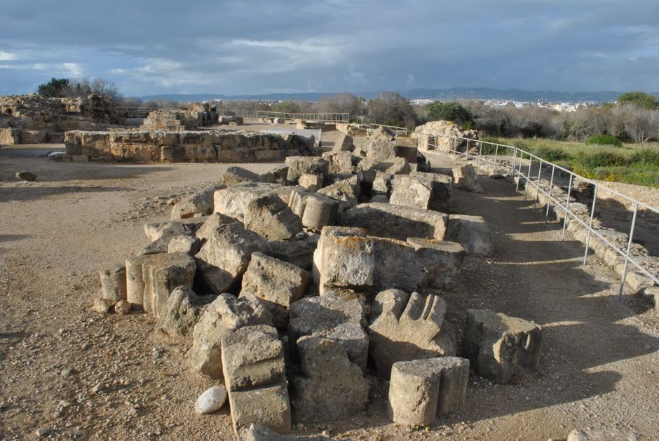 Ruines de marbre et fragments de colonnes éparpillés sur la plaine herbeuse de Milet, le théâtre visible au loin