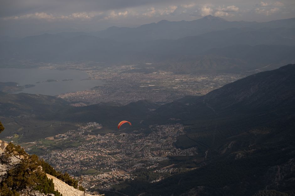 Colorful paraglider canopies filling the sky above Ölüdeniz's Babadağ launch point