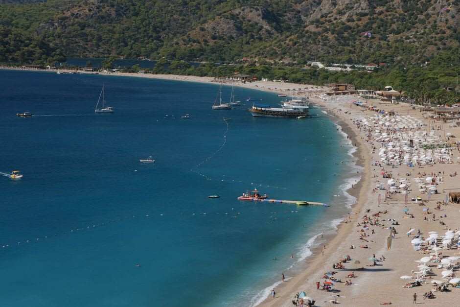 Sunbathers along the white sand spit enclosing Ölüdeniz's sheltered lagoon