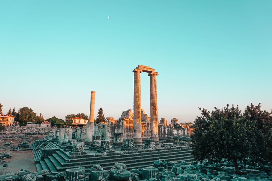 The Temple of Apollo columns at Side silhouetted against the sunset with crowds gathered on the rocks