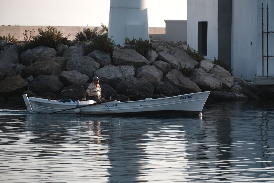 A lone fisherman casting a line from Sinop's rocky peninsula at dusk