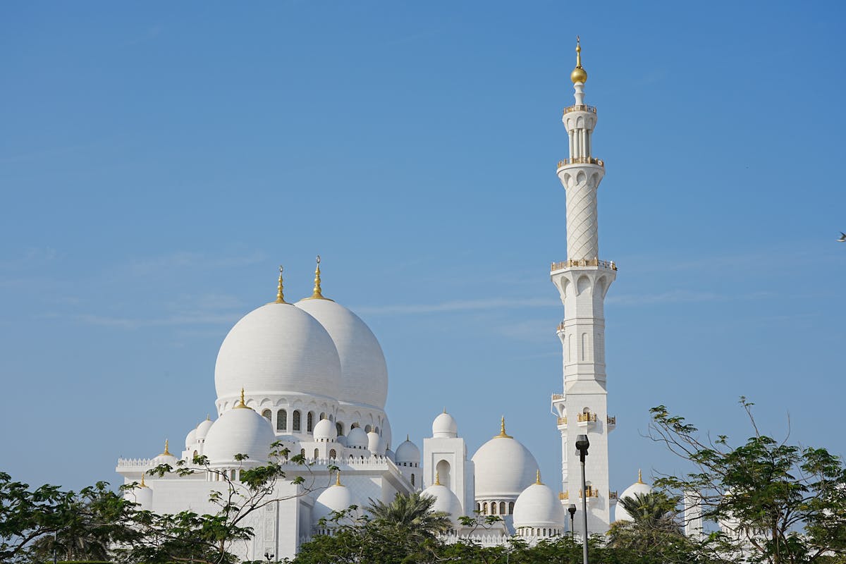 The Sheikh Zayed Grand Mosque reflecting in pools at golden hour