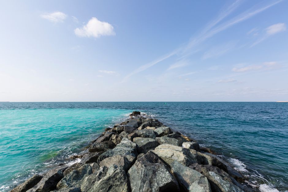 A sandy cove with calm turquoise water at Al Mamzar Beach Park