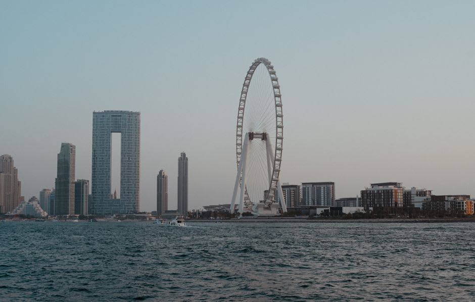 Passerelle piétonne reliant JBR à Bluewaters Island au crépuscule avec la ligne d'horizon de la Marina derrière