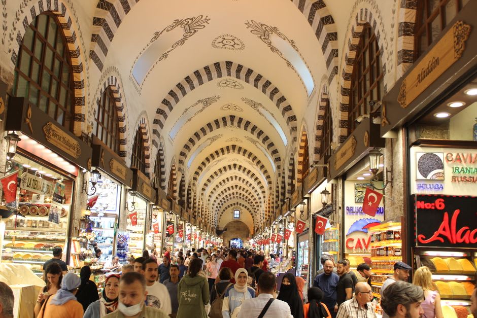 Narrow lane of Dubai Spice Souk with vendors and hanging dried goods