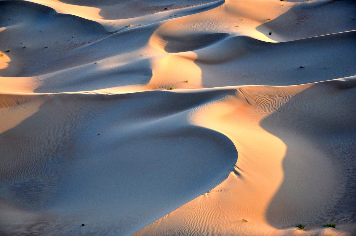 Desert sand dunes glowing orange at sunset near Dubai