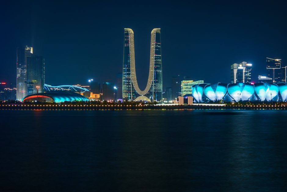 Torres iluminadas reflejándose en el lago en Jumeirah Lake Towers después del atardecer