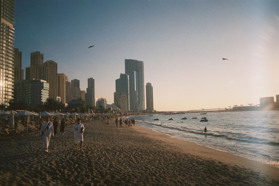 Sandy beach at La Mer with the Dubai coastline and Gulf waters at sunset
