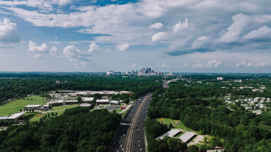 Piedmont Park meadow with the Atlanta skyline rising beyond the trees