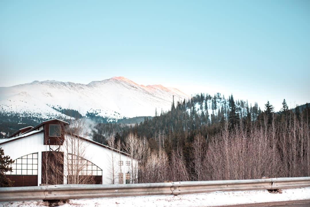 View from the BreckConnect gondola over green summer ski runs and the high peaks above Breckenridge