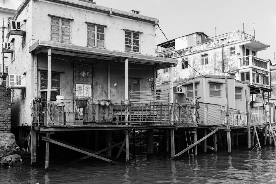 Historic storefronts perched on stilts against the limestone bluff in Calico Rock's Old Downtown, Arkansas