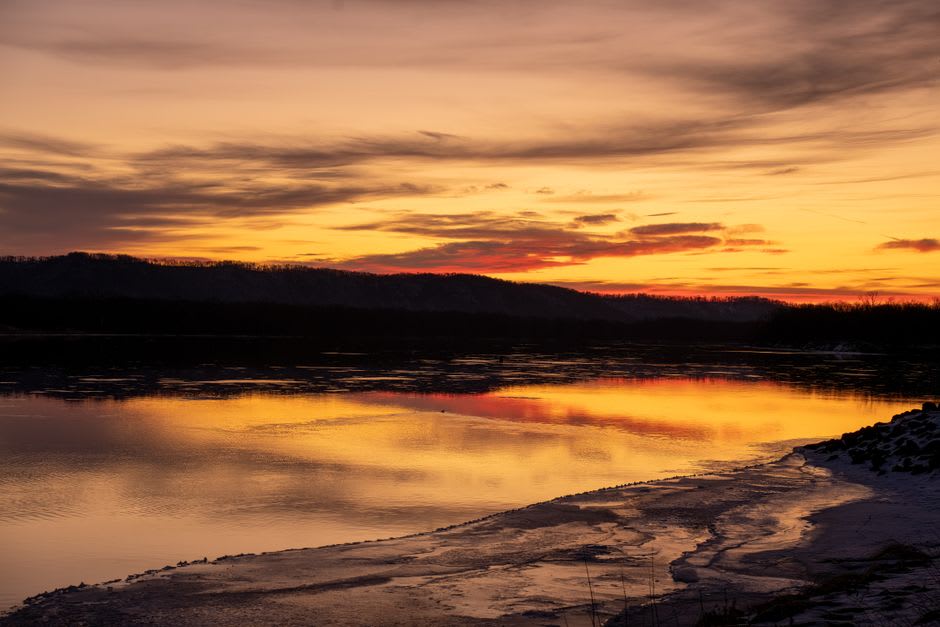 The White River glowing orange at sunset below the limestone bluffs of Calico Rock, Arkansas