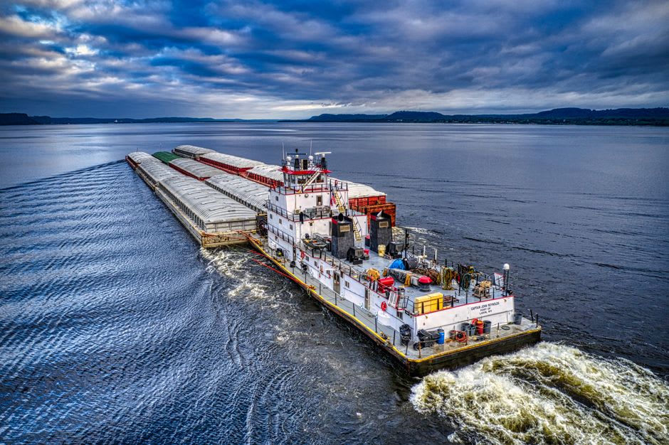 A towboat pushing barges along a bend of the Mississippi River near Cape Girardeau, Missouri