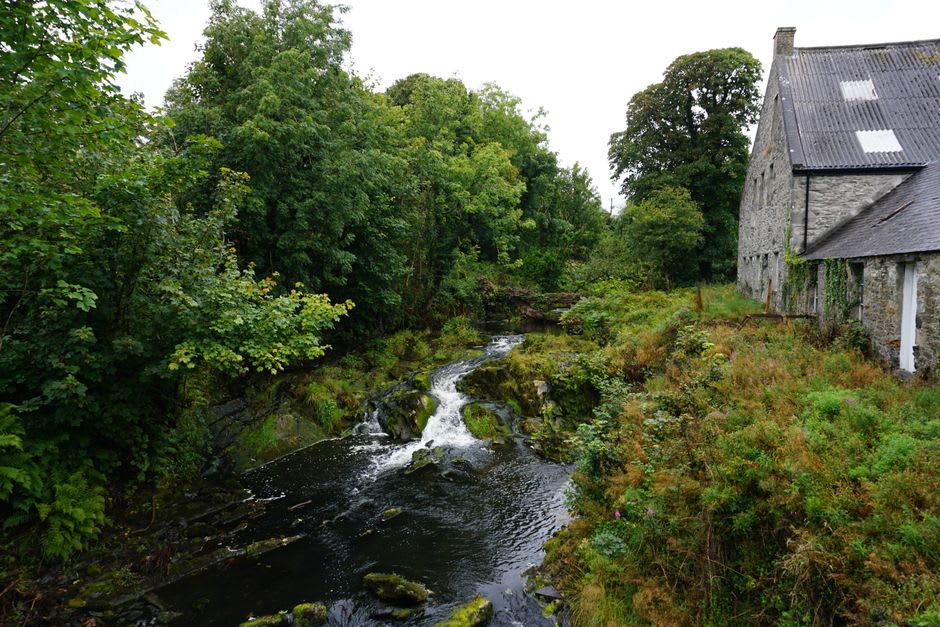The limestone Cedar Creek woolen mill and rushing millrace in Cedarburg, Wisconsin