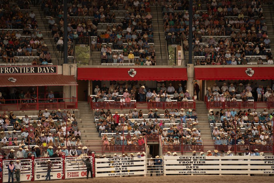 Cowboys and horses in action at the outdoor arena of Cheyenne Frontier Days rodeo