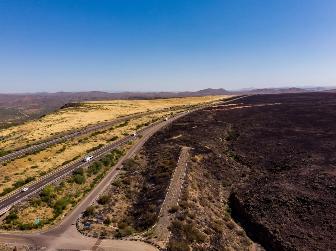 A trail of crushed black cinder winding through ropey lava formations at Craters of the Moon