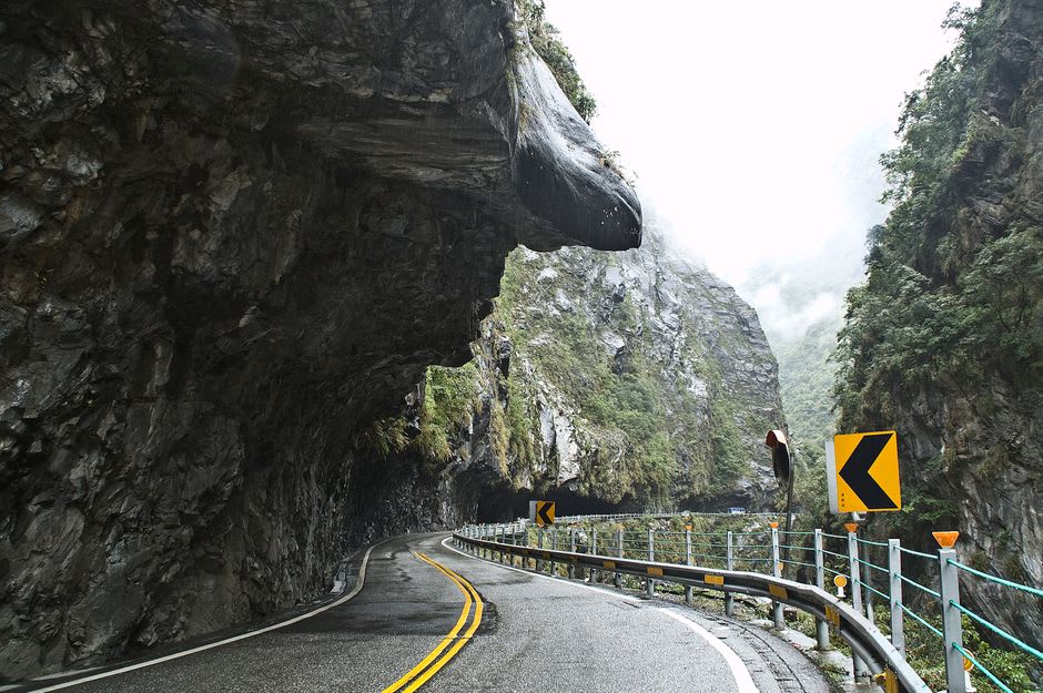 Steep granite cliffs of Table Rock rising above the narrow highway through Dixville Notch, New Hampshire