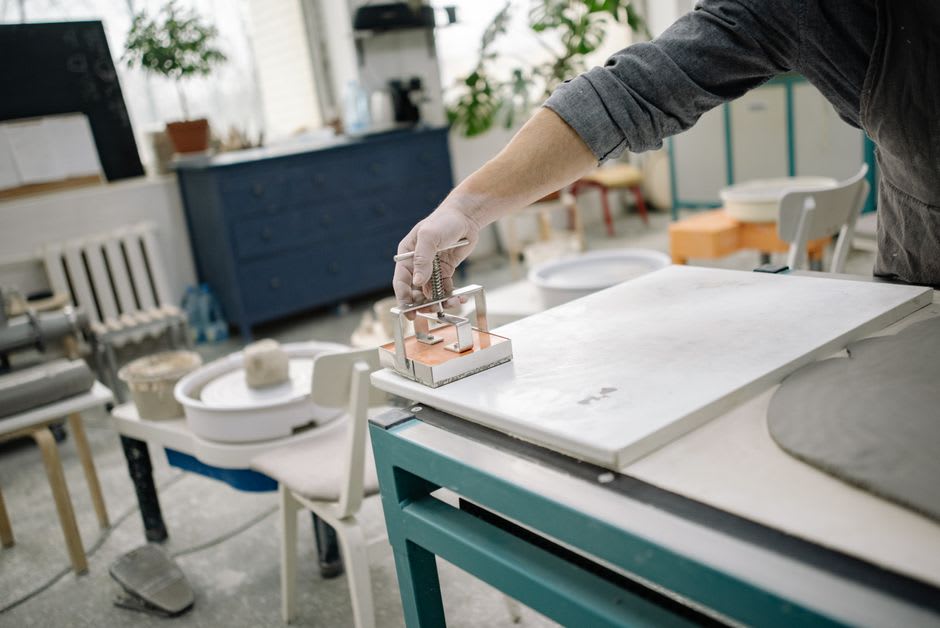 A craftsperson pressing clay into a historic tile mold at the Moravian Pottery and Tile Works in Doylestown, Pennsylvania