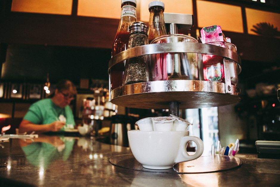A classic diner counter in downtown Effingham, Illinois with regulars chatting over coffee