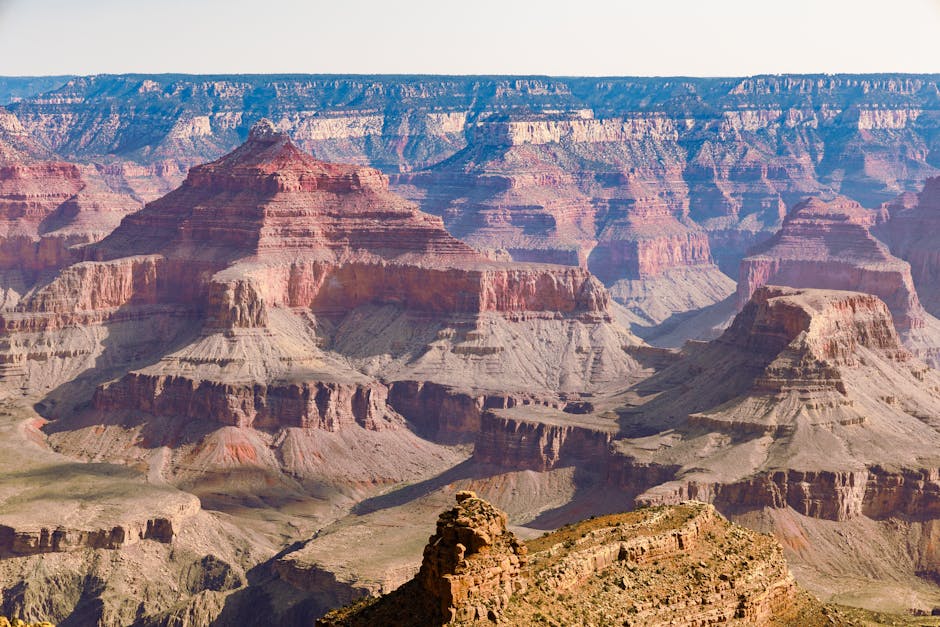 The Grand Canyon at sunrise with golden light illuminating layered rock walls