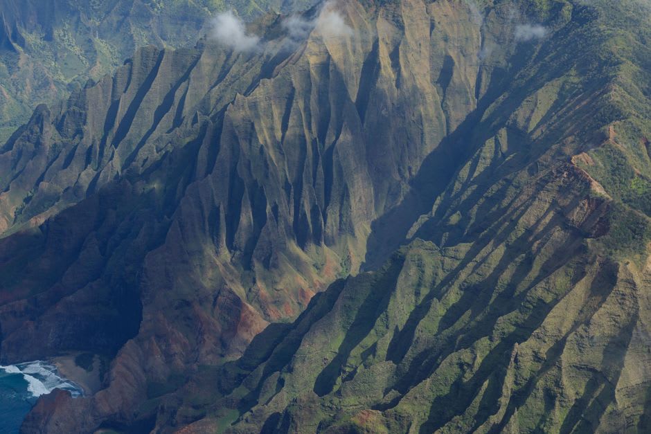 Waterfalls and sea caves along the roadless Na Pali Coast seen from the water