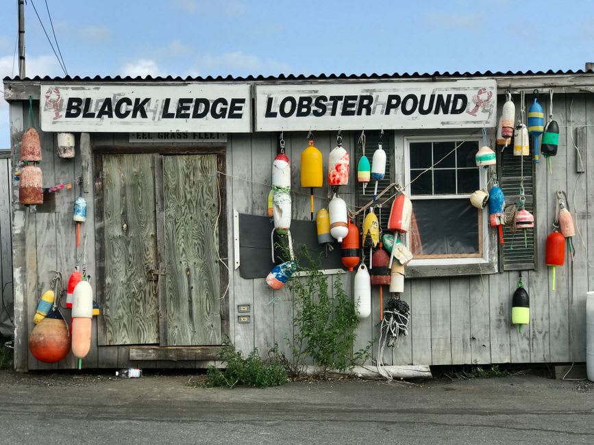 Weathered wooden shops and a low bridge over the tidal river at Dock Square in Kennebunkport