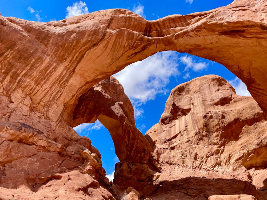 A natural stone arch framing a distant desert landscape in Arches National Park