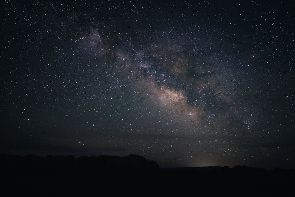 The starry night sky and Milky Way arching over a Utah desert landscape