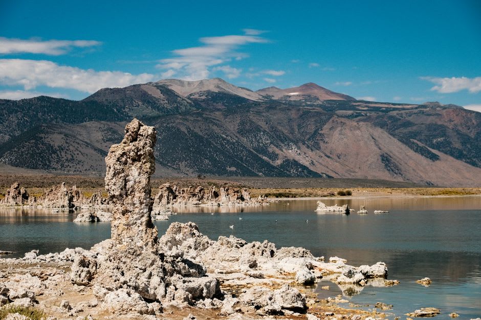 Still dawn reflection of tufa towers and the Sierra Nevada in the glassy surface of Mono Lake