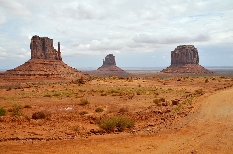 A Navajo guide's truck parked beside a sandstone arch in the Monument Valley backcountry