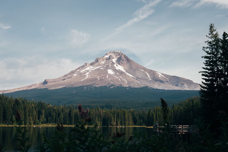 The rustic stone-and-timber facade of Timberline Lodge with the snowfields of Mount Hood rising behind it