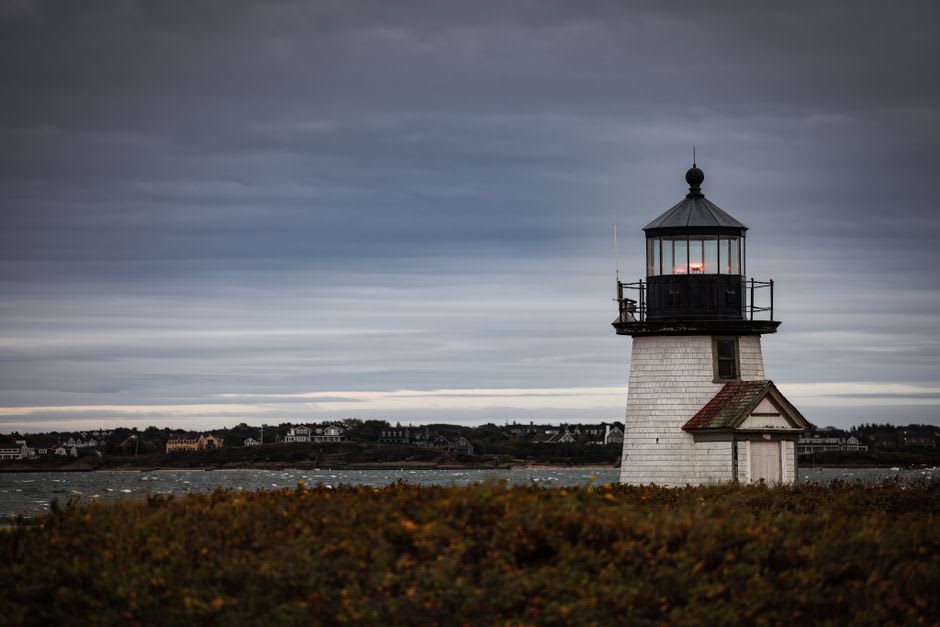 Brant Point Lighthouse glowing in the low evening light at the harbour entrance