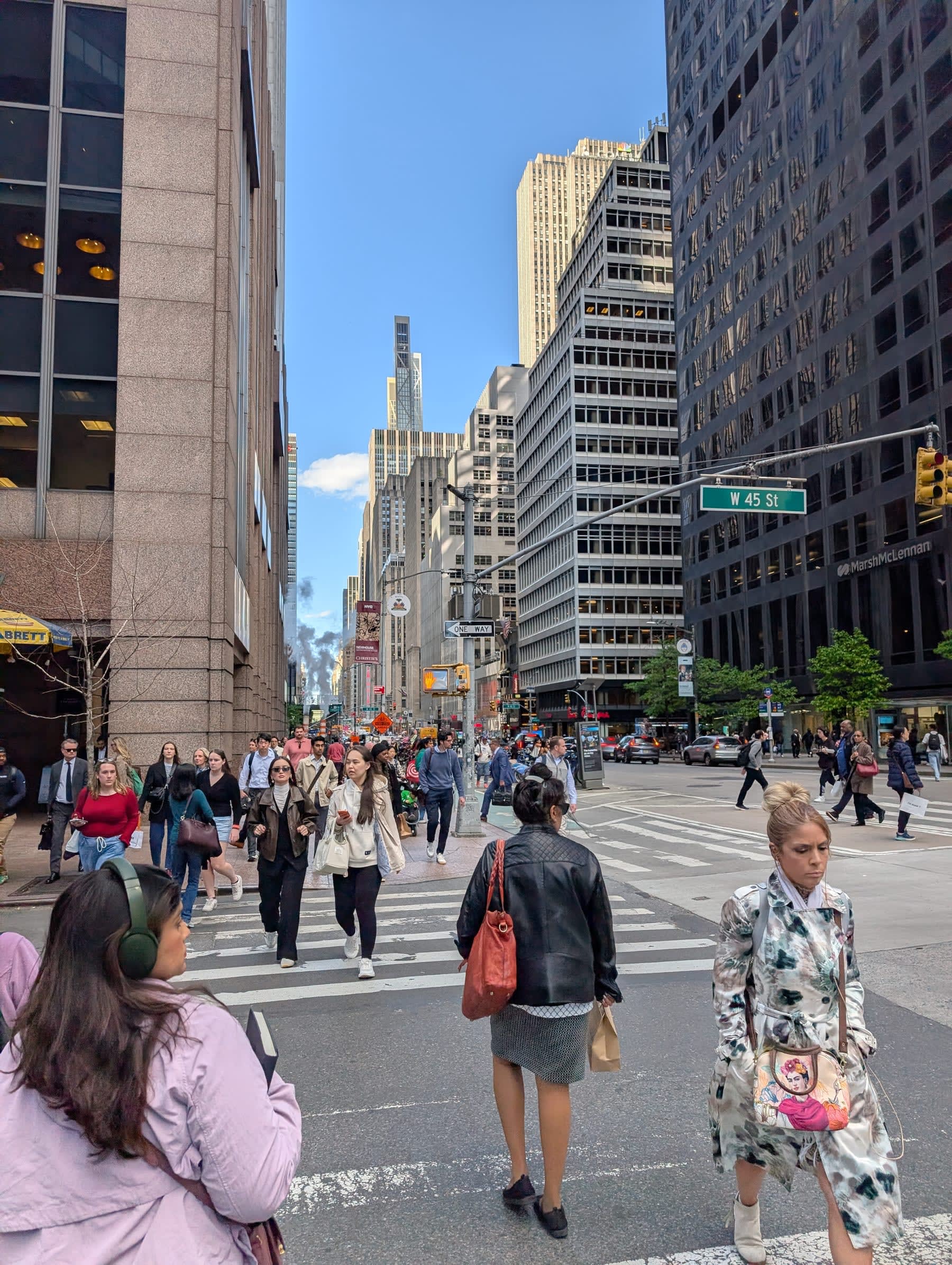 West 45th Street at nine in the evening — crowds crossing the intersection in every direction, the midtown towers rising on both sides, a green street sign marking the block