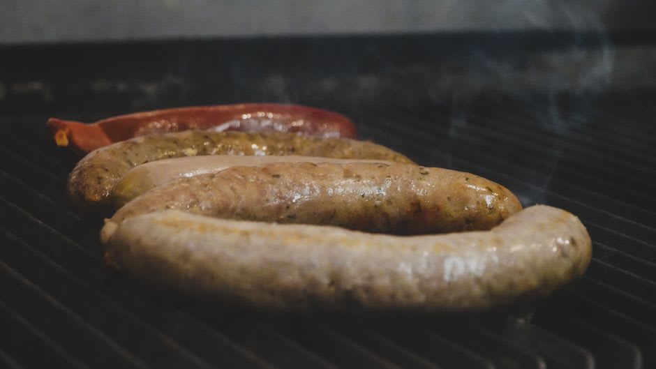 Fresh boudin links and candied yams served at a Creole diner counter in Opelousas, Louisiana