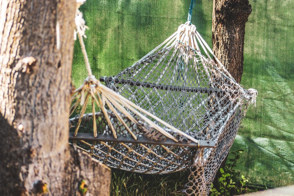 A hand-woven rope hammock strung between live oaks at the Hammock Shops near Pawleys Island, South Carolina