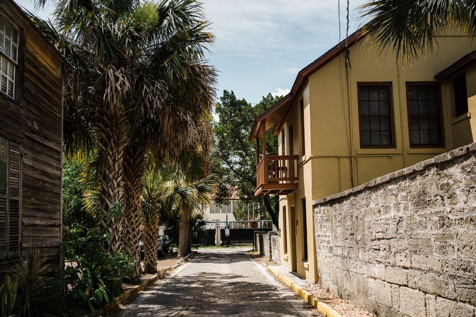 A narrow lane in the old town with leaning colonial houses and hanging jasmine