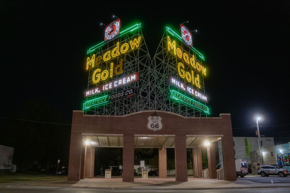 A restored neon Route 66 sign glowing in the Tulsa dusk