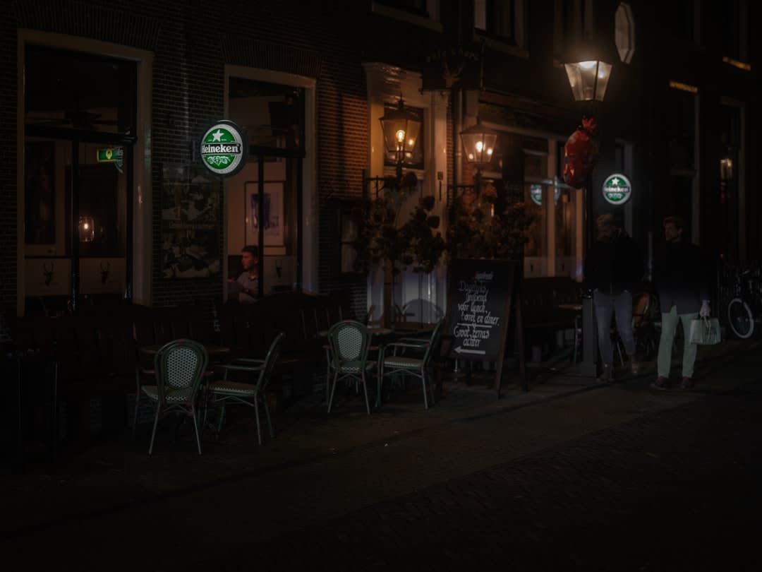 String lights and outdoor dining tables set up along the brick-paved Main Street of Zionsville, Indiana at dusk