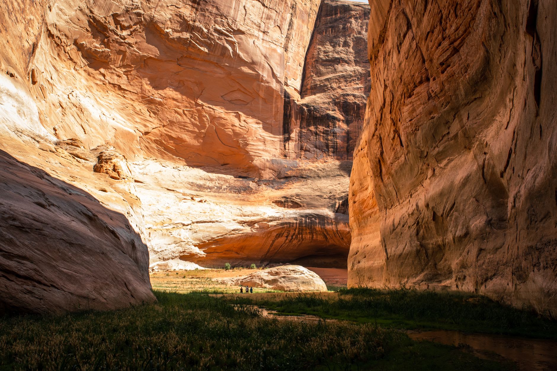 A narrow sandstone slot canyon glowing orange where light filters down from above