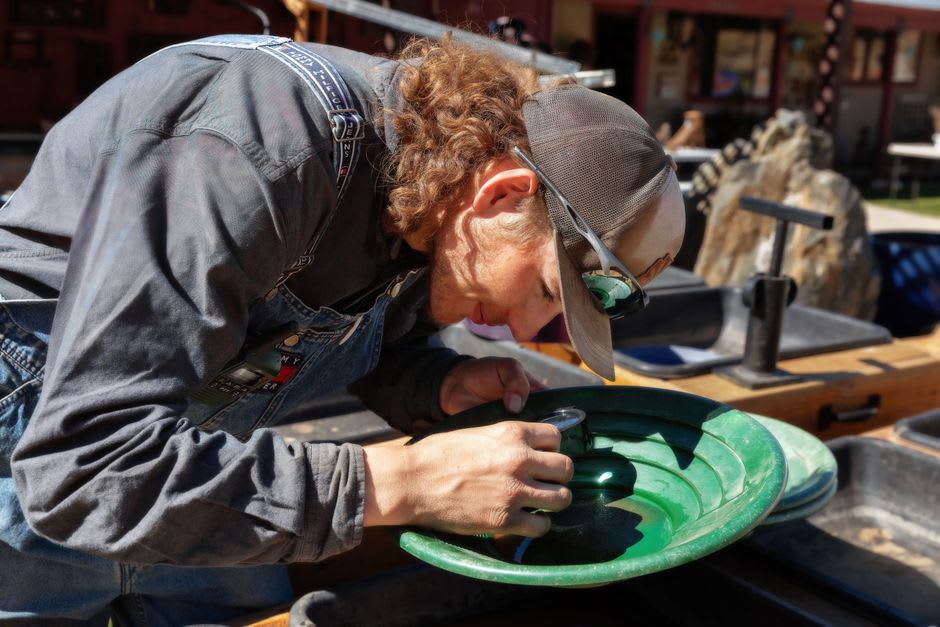 Actors in 1850s period costume panning for gold at the recreated diggings of Sovereign Hill, Ballarat