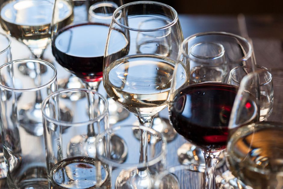 A small glass of dark, viscous fortified Muscat wine held up against the light at a Rutherglen cellar door