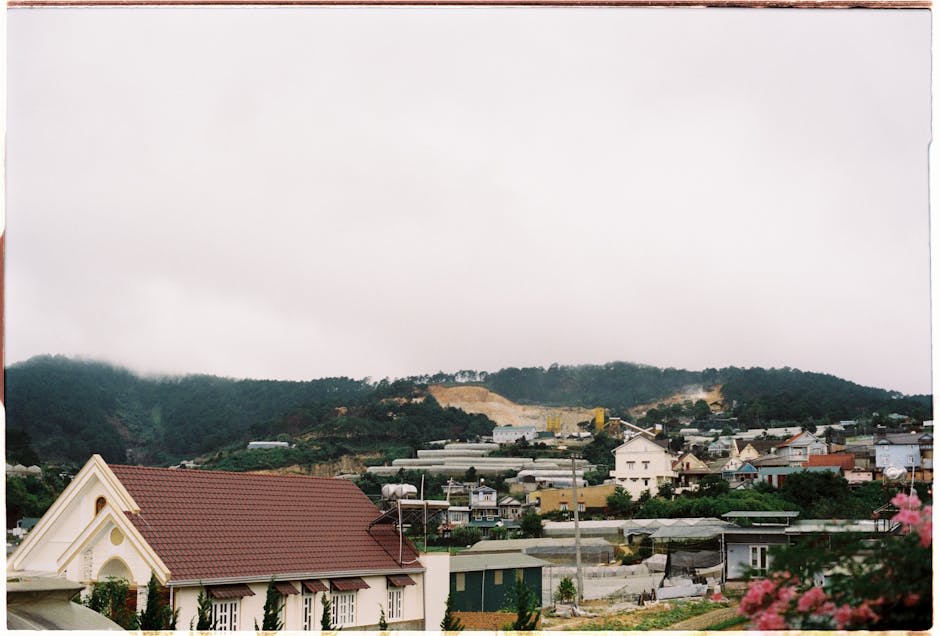 Captivating view of a mountain village in Dalat under a cloudy sky with charming houses and lush greenery