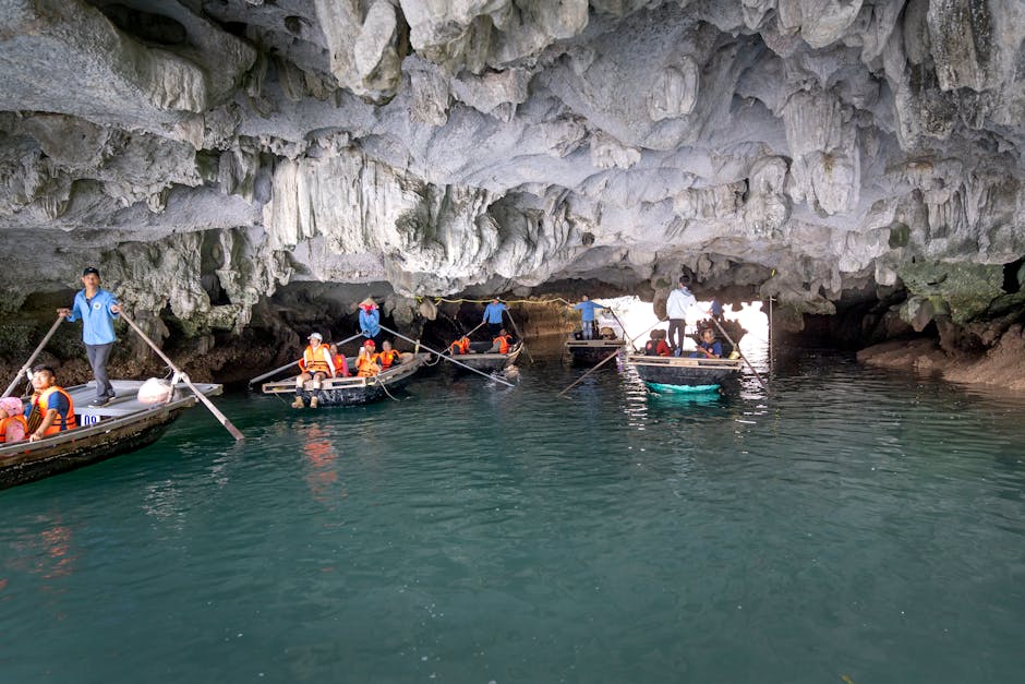 Tourists on boats explore a stunning limestone cave in Ha Long Bay
